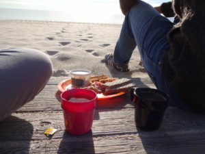 Sitzen am Strand mit einfachem Frühstück 
