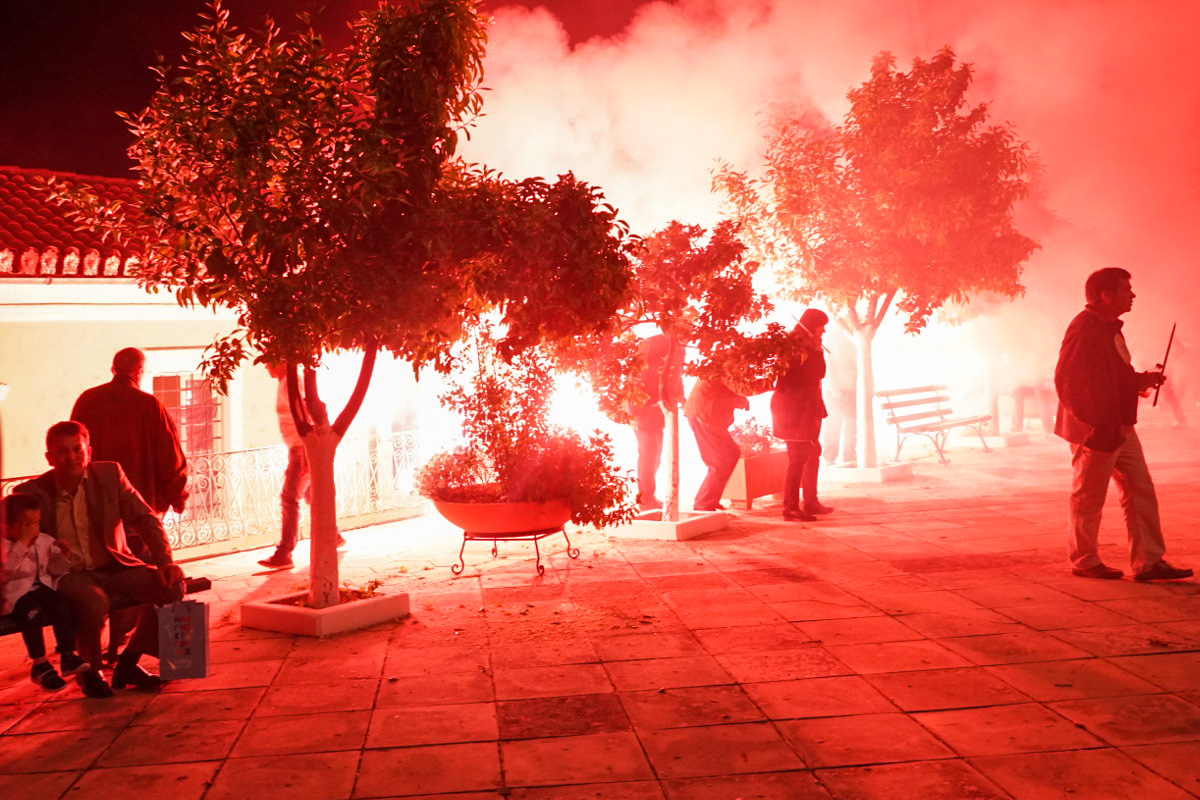 Bäume und Menschen in rotem Rauch - Ostern Leonidio