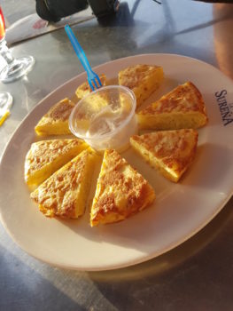 Rundes Omlett in Ecken geschnitten und um eine Sauce in der Mitte verteilt - Tapas essen Spanien